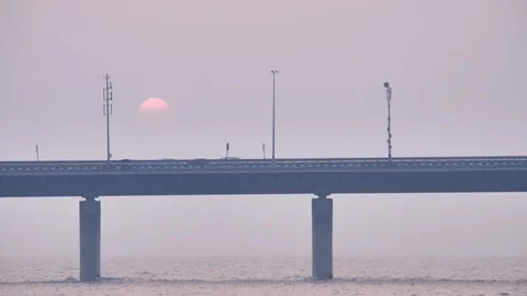 Vehicles passing on a modern bridge while sun is setting in the background Stock Footage 86537514