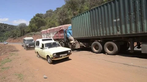 Vehicles passing a road traffic accident involving two trucks, Kenya Stock Footage 82575487
