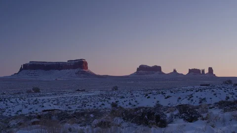 Vehicles passing through snow covered Monument Valley area Stock Footage 104113442