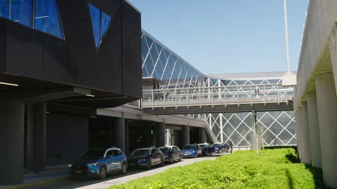 Vehicles Queue Beneath Elevated Walkway at Modern Airport Video stock 333537881