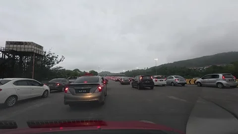 Vehicles queue patiently to enter a highway toll plaza during a traffic jam. Stock Footage 307915803