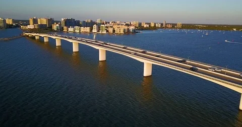 Vehicles running on the bridge in river and city buildings in background Video stock 83695236