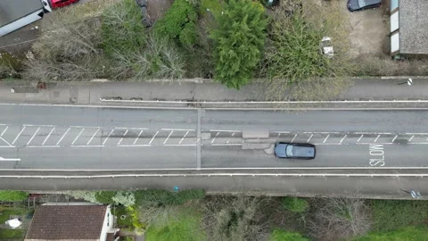 Vehicles slowly driving around  large pothole UK croad overhead birds eye 스톡 동영상 234884483