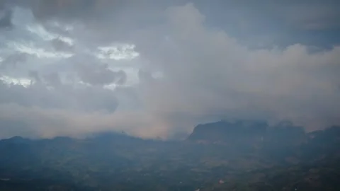Veiled Alpine Terrain Under Shifting Cumulus Formations at Dusk Stock Footage 316797619