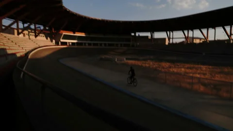 Velodrome cyclist rotates in an empty stadium, light and shadow - 4K  Video stock 146900032