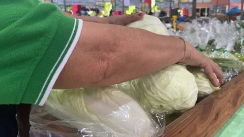 Vendor adding vegetables white cabbage at the stand in the market. Video stock 204966801