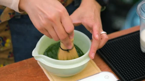 Vendor beating matcha mixture with chasen whisk Видео 338273646