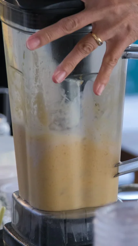 Vendor blending fresh mango into smoothie shake Stock Footage 345799987