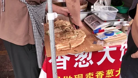 Vendor Cuts a Large Scallion Pancake at Shanghai Street Stall Stock Footage 340176917