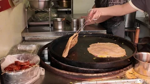 Vendor Flips Multiple Flatbreads on Shanghai Breakfast Griddle 스톡 동영상 340176986
