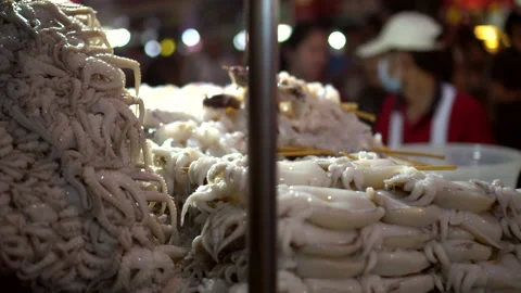 Vendor hands piling cuttlefish skewers marinated wait for bbq grill in Bangko Stock Footage 158993052