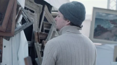 Vendor hanging old frames at antique fair Stock Footage 61410831