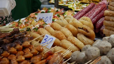 A vendor picks up deep-fried sticky rice cakes stuffed with savory fillings Video stock 312110350