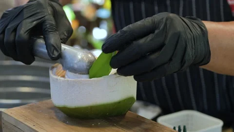 Vendor preparing coconut ice cream in shell 库存影片 338272998