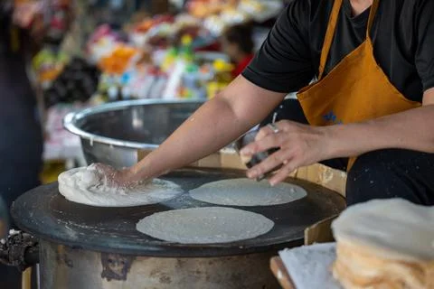 Vendor preparing flatbread at Khlong Toei Market stall Fotos Stock