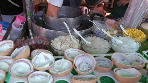 Vendor scooping coconut ice cream and sell to customer Stock Footage 120619473