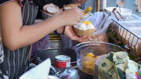 Vendor scooping coconut ice cream with ripen mango and sell to customers Stock Footage 120620642