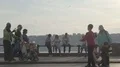 Vendor sending soap bubbles onto people going by, children trying to catch them HD Footage