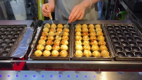Vendor Turns Round Snacks on a Hot Griddle at Dandong Market Stock Footage 340176155