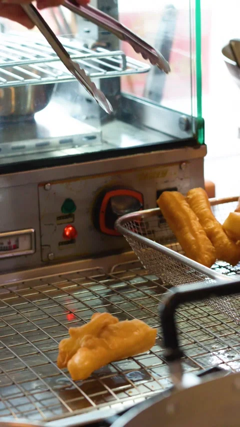 Vendor Using Tongs to Arrange Deep Fried Dough Sticks in Bangkok Video stock 341068169