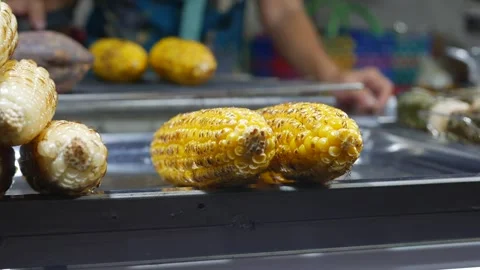 Vendors stack freshly grilled corn, ready to serve hungry customers at a vibrant Stock Footage 313485704