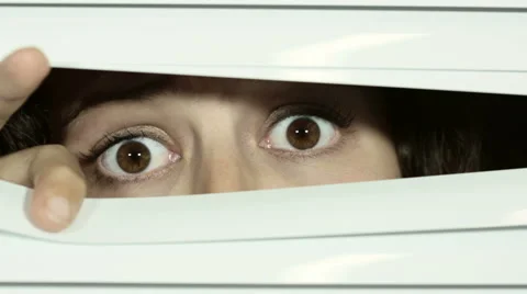 Venetian blinds pulled open by young woman who gets a big fright. Video stock 54332565