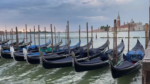Venetian empty gondolas bob on the waves near the shore. Stock Footage 335091866