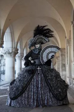Venice Carnival Figure in colourful costume & mask Arcade of Doge's Palace Stock Photos