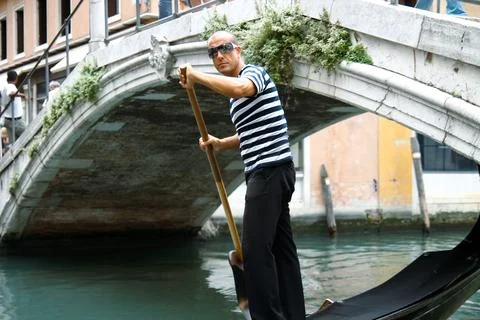 Venice, Italy - July 25th 2011 - Gondolier in traditional striped attire na.. Stock Photos
