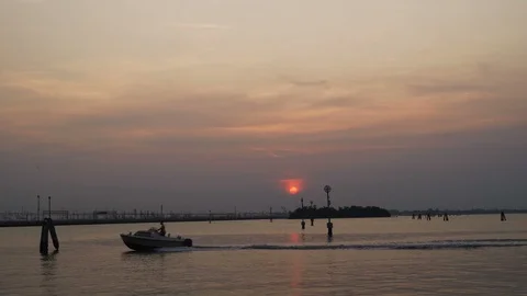 Venice lagoon at sunset in slomo as speed boat sails past Stock Footage 117834843