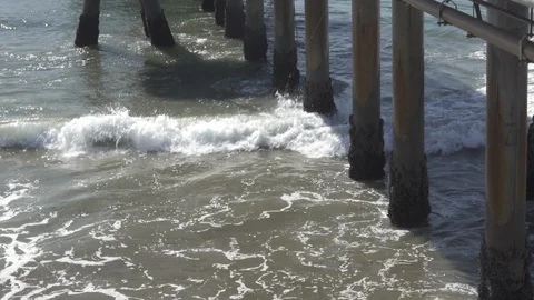 Venice pier looking down the pier, small waves crashing against pylons Stock Footage 121313988