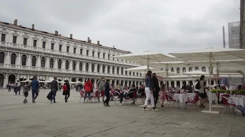 Venice, St. Mark's Square Piazza San Marco, cafe, tourists pass by Stock Footage 234716245