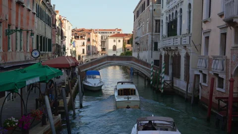 Venice water taxis navigate narrow canals and under bridge Stock Footage 220003953