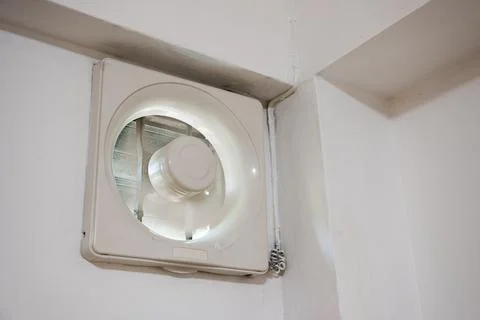 Ventilation fan installed on wall with working in bedroom Foto stock