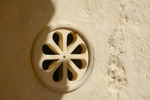 Ventilation grid on the front of a house. Made of stone with a decorative sha Stock-Fotos