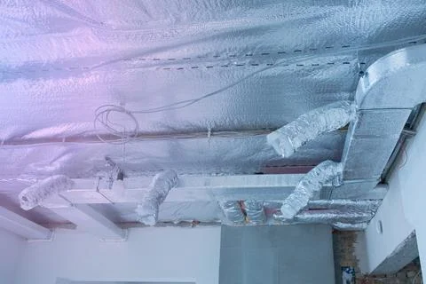 Ventilation pipes in silver insulation material on ceiling Foto stock