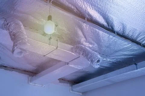 Ventilation pipes in silver insulation material on ceiling Stock Photos
