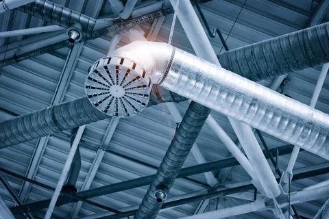Ventilation pipes in silver insulation material hanging from the ceiling insi Foto stock