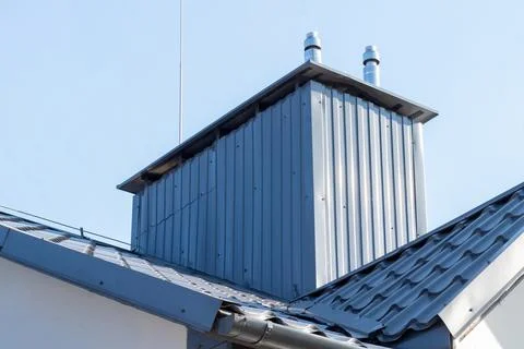 Ventilation system with chimneys and ducts on the roof of a residential building Stock Photos