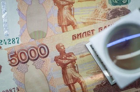 Verification of Russian banknotes for authenticity under a magnifying glass Stock Photos