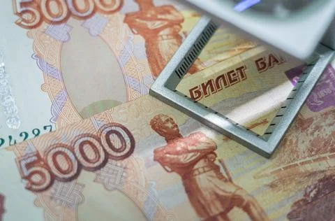 Verification of Russian blurred banknotes for authenticity under a magnifying Stock Photos