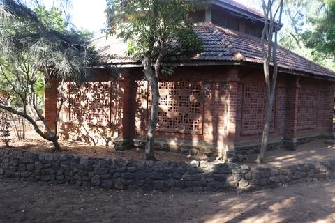 Vernacular architecture structure surrounded by trees in village courtyard Stock Photos