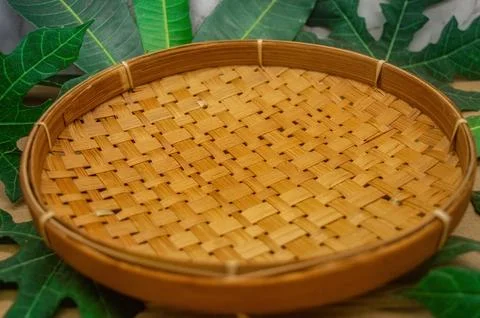 A versatile round woven bamboo tray, showcasing its natural texture and art.. Stock Photos