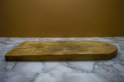 A versatile scene featuring a rustic wooden cutting board resting on a gray.. Foto stock