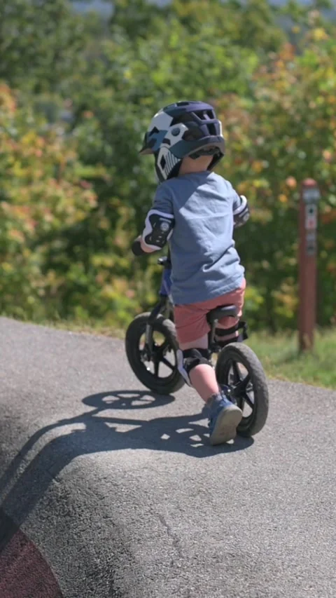 Verti al screen White toddler boy pausing on ridge at Johnson City park usa Video stock 323099268