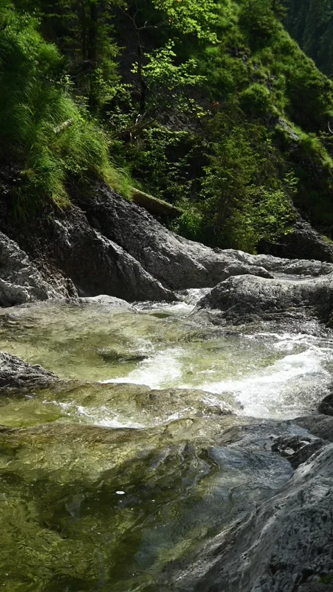 Vertial shot of a mountain stream cascading into a gorge Stock-Footage 260888730