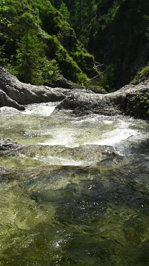 Vertial shot of a mountain stream cascading into a gorge Stock-Footage 260888878