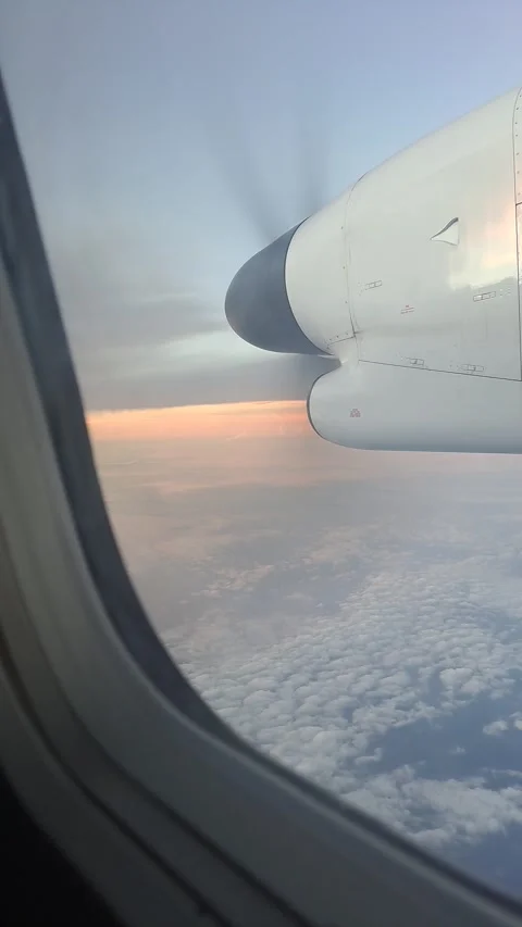Vertical 4K of airplane window view seat above clouds with rotating propeller. Stock Footage 273190014