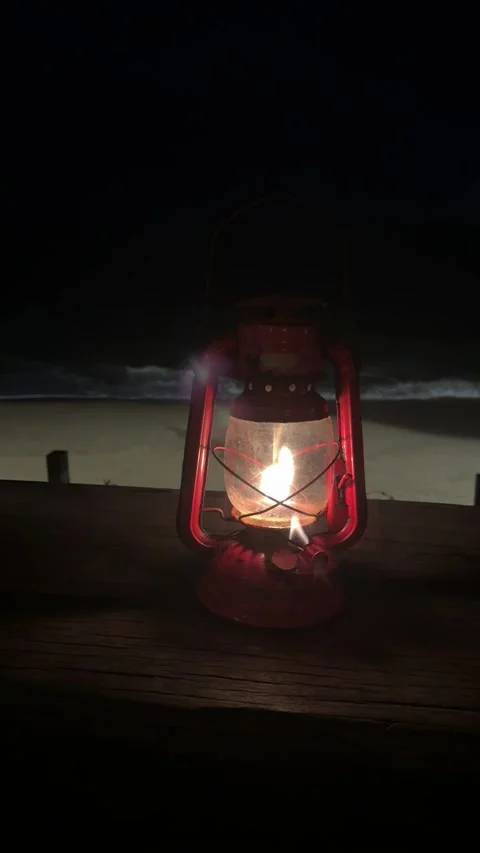 Vertical 4K Atmospheric Glow of Red Kerosene Lamp at Night Sea 動画素材 332038407