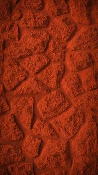 A vertical 4K background featuring a striking red grainy stone wall texture.. Illustrazione stock